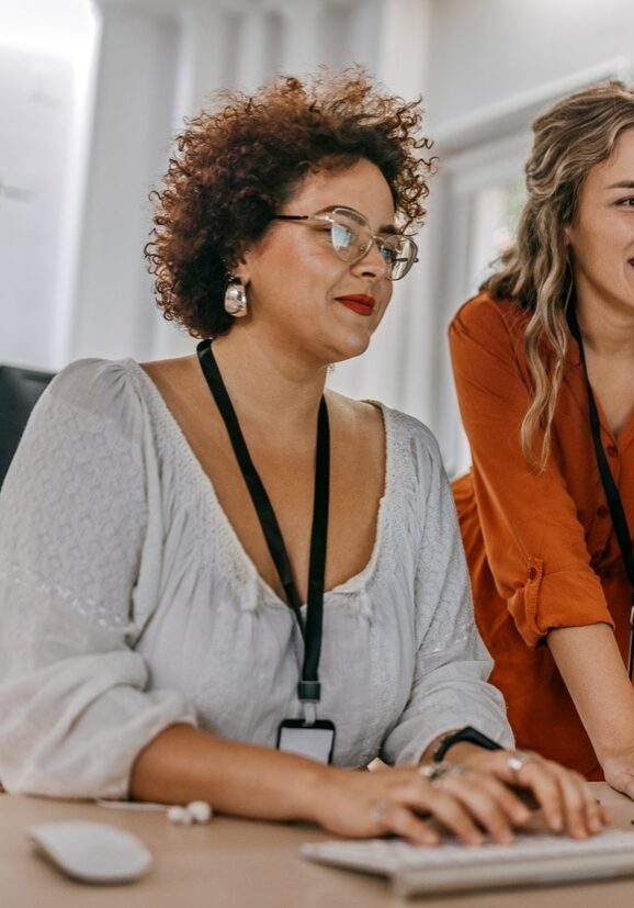 Two businesswomen working together on computer at office