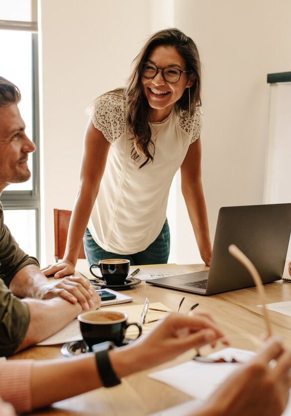 Group of multi ethnic executives discussing during a meeting. Business man and woman sitting around table at office and smiling.